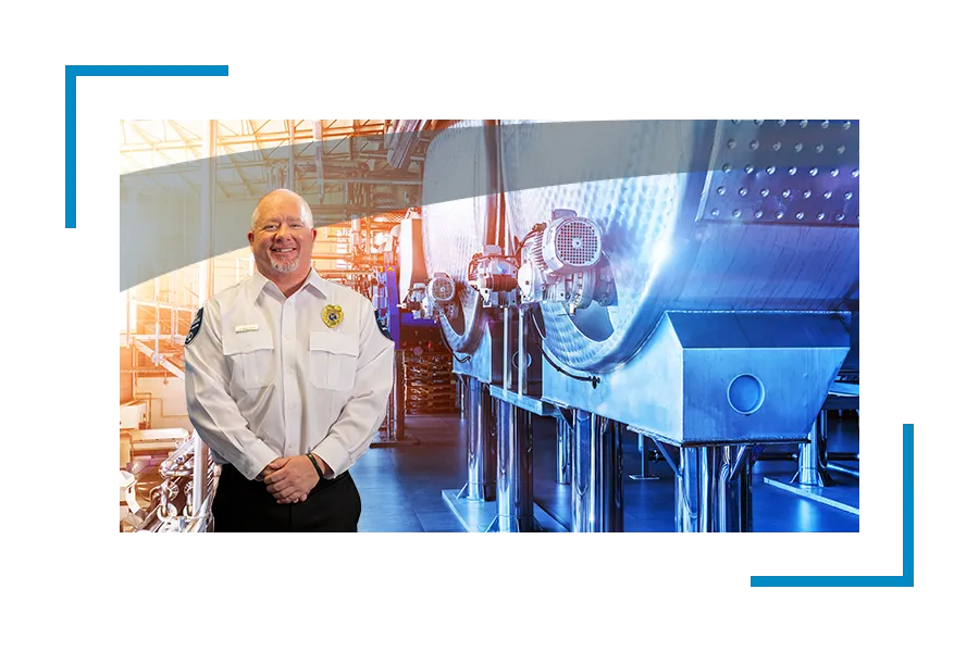 Petrochemical security services, chemical facility security: Smiling Allied universal security professional near industrial equipment