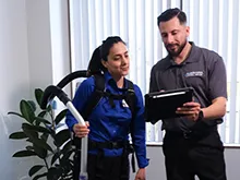 A man and women having a conversation. Women has cleaning supplies in her hand. 